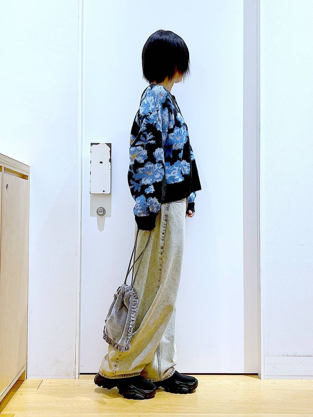 ブラック系のブーツ、グレー系のショルダーバッグ、ベージュ系のデニムパンツを着用したレディースの秋コーディネートの4枚目の写真