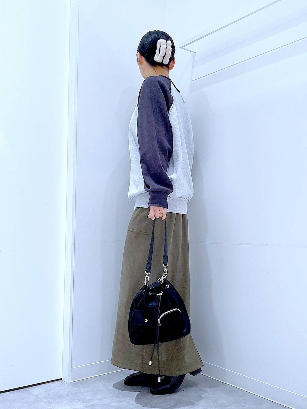 ブラック系のショルダーバッグ、グレー系のニット/セーター、ブラック系のブーツを着用したレディースの冬コーディネートの3枚目の写真