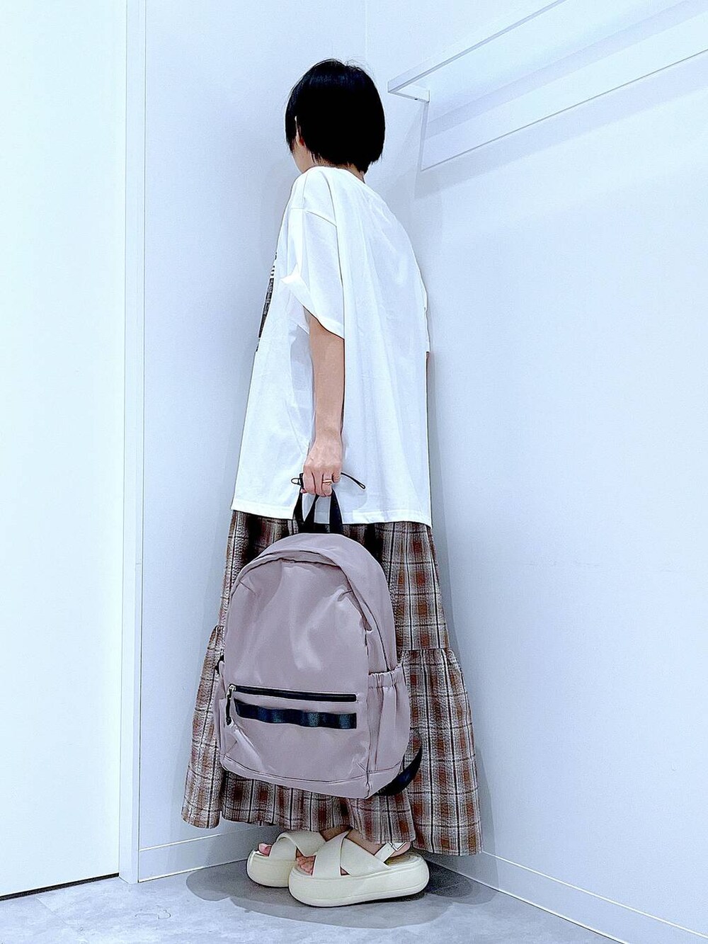 ベージュ系のバックパック/リュック、ホワイト系のサンダル、ブラウン系のワンピースを着用したレディースの夏コーディネートの3枚目の写真