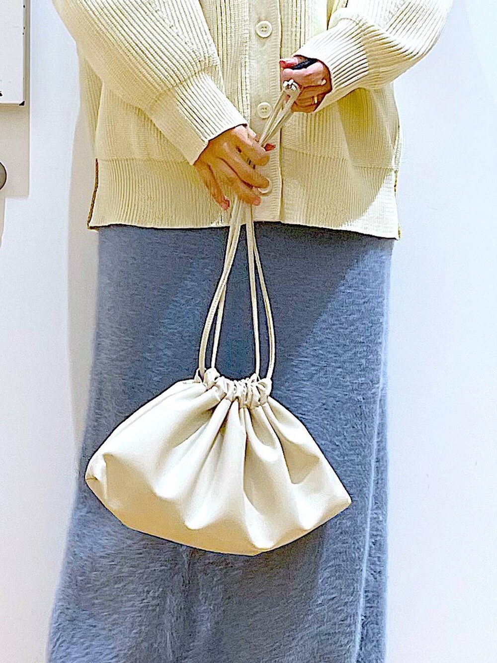 ベージュ系のブーツ、ベージュ系のニット/セーター、ベージュ系のショルダーバッグを着用したレディースの冬コーディネートの9枚目の写真