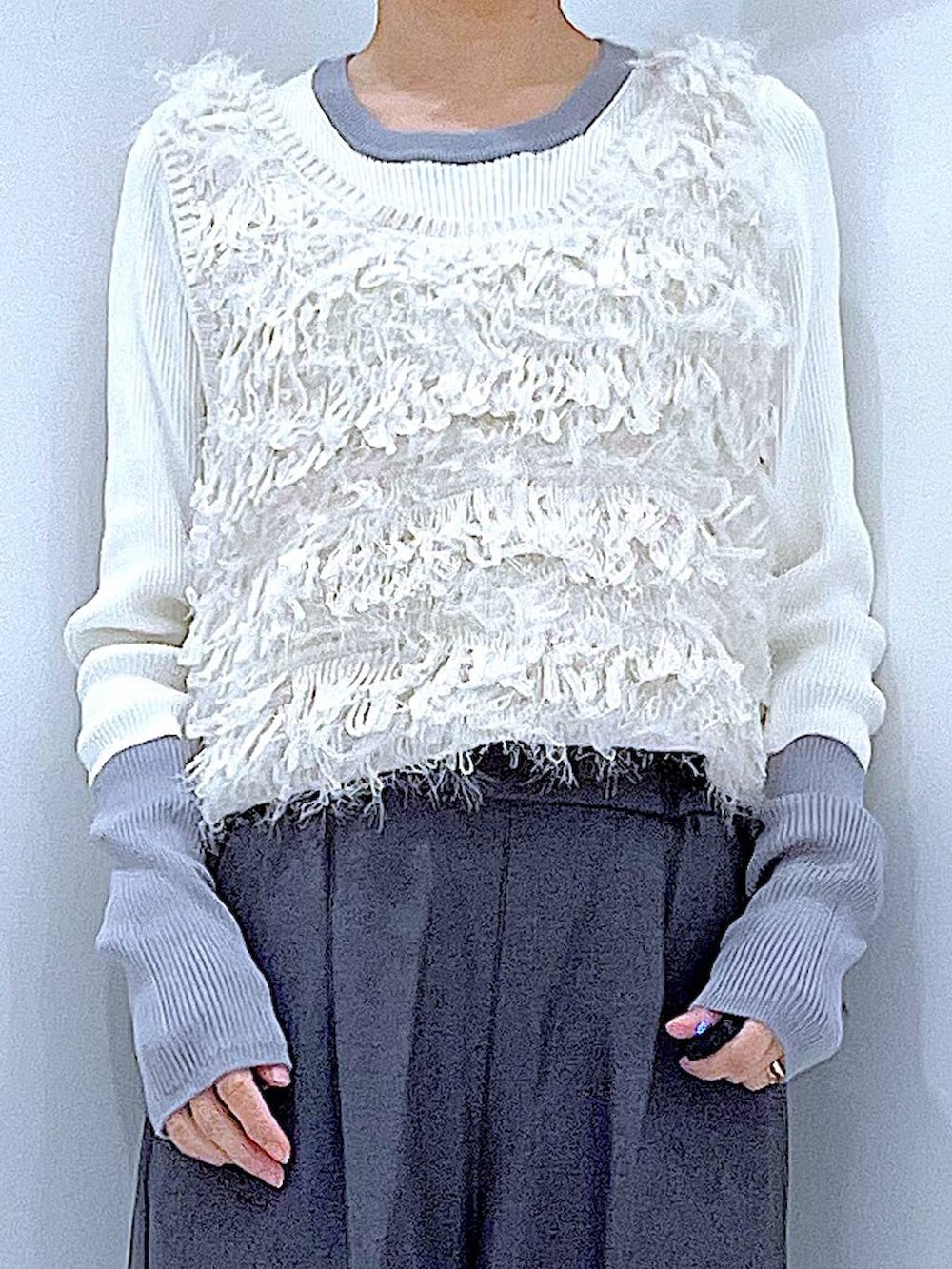 ブラック系のブーツ、グレー系のスラックス、ホワイト系のベストを着用したレディースの冬コーディネートの7枚目の写真