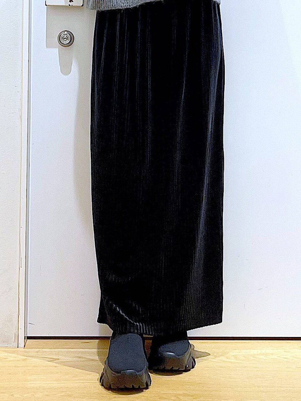 ブラック系のバックパック/リュック、ブラック系のスカート、ブラック系のブーツを着用したレディースの秋コーディネートの8枚目の写真