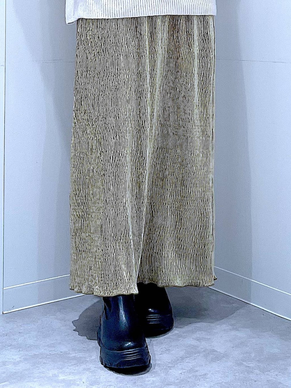 ブラック系のブーツ、ブラック系のショルダーバッグ、グリーン系のスカートを着用したレディースの冬コーディネートの8枚目の写真