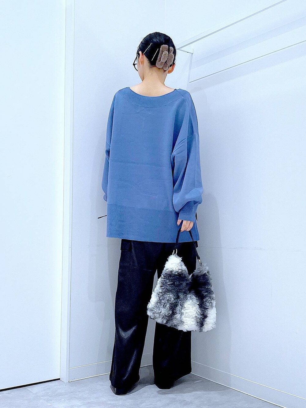 ブルー系のニット/セーター、ブラック系のブーツ、ブラック系のショルダーバッグを着用したレディースの冬コーディネートの5枚目の写真