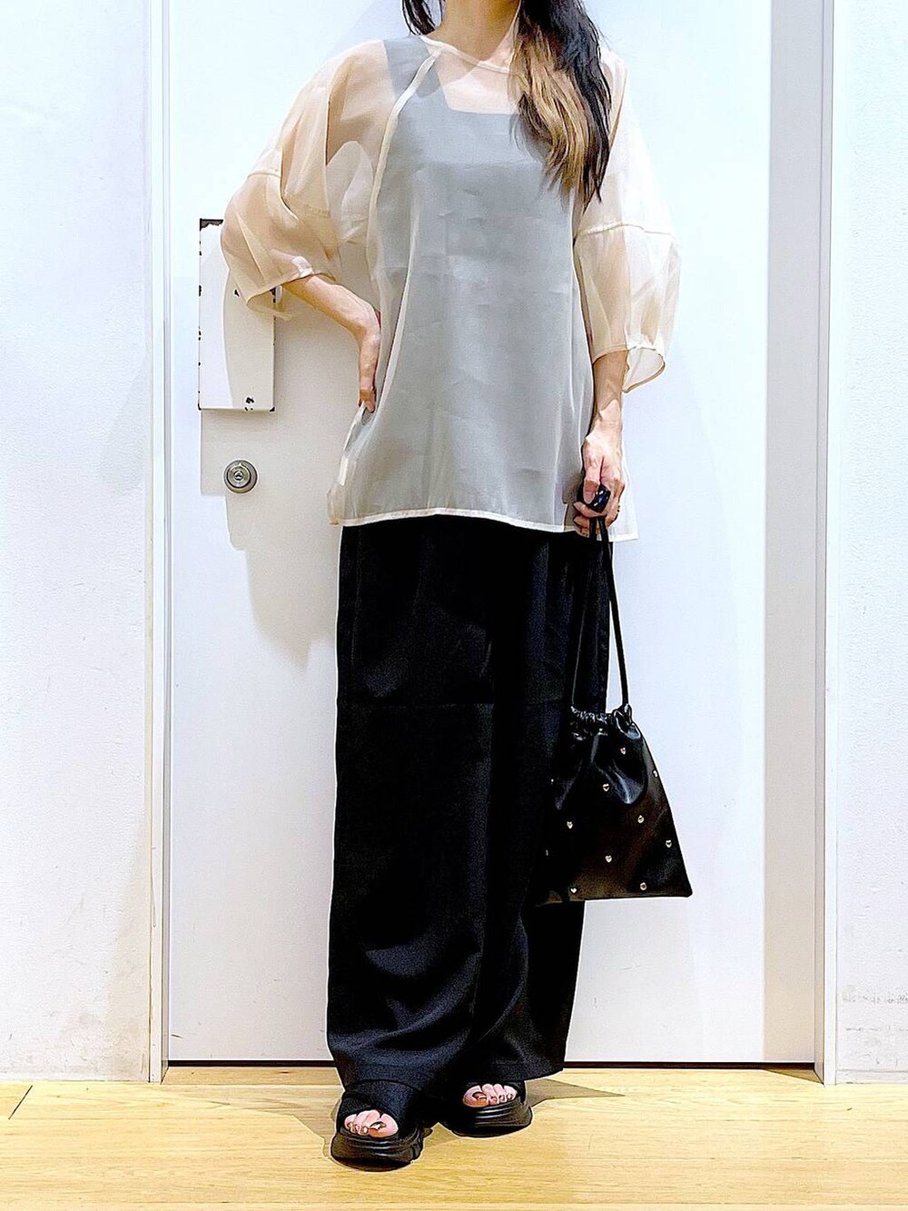 ブラック系のサンダル、ブラック系のニット/セーター、ブラック系のショルダーバッグを着用したレディースの夏コーディネートの6枚目の写真