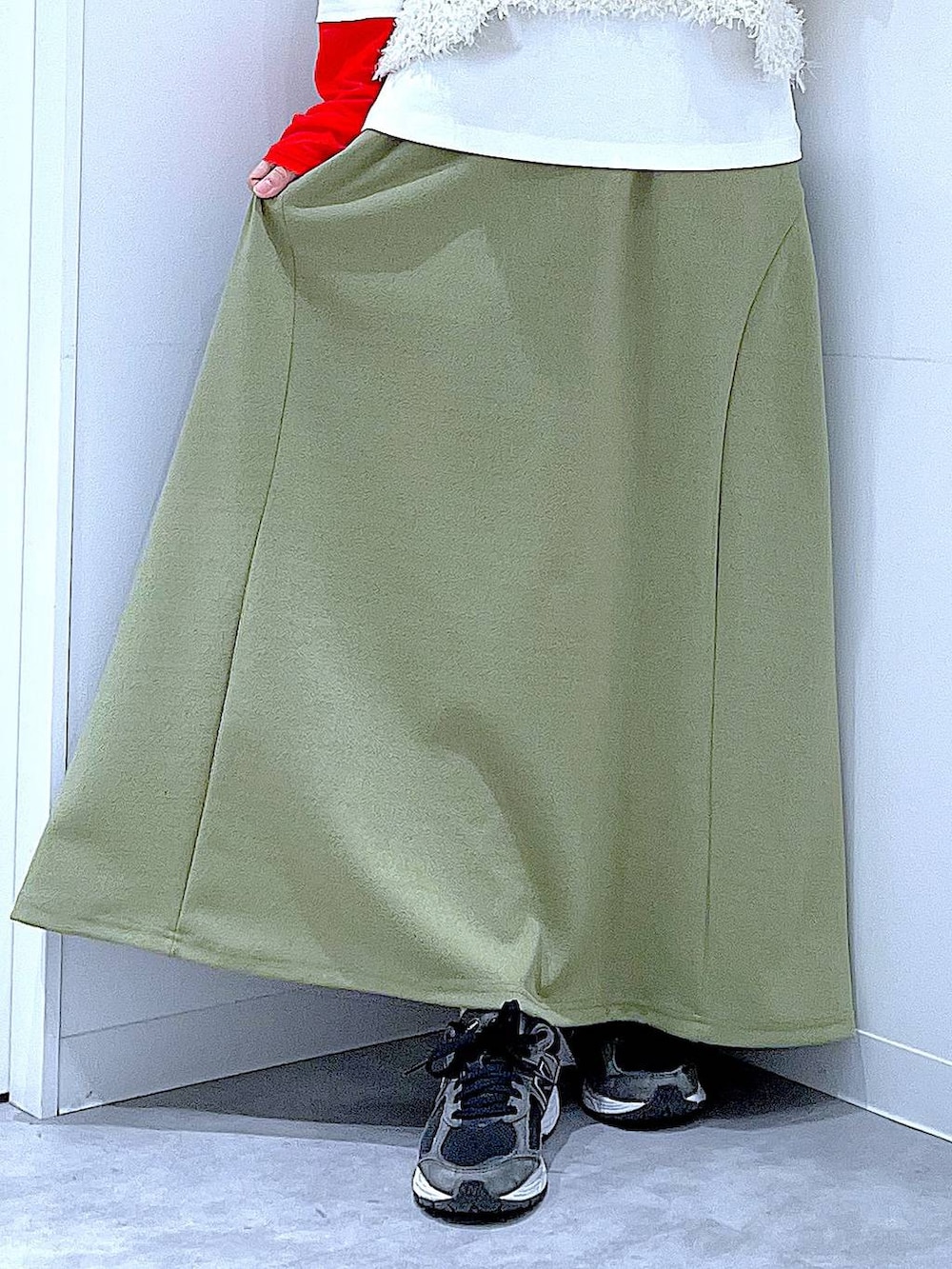 グリーン系のスカート、ホワイト系のTシャツ/カットソー、ベージュ系のベストを着用したレディースの冬コーディネートの8枚目の写真