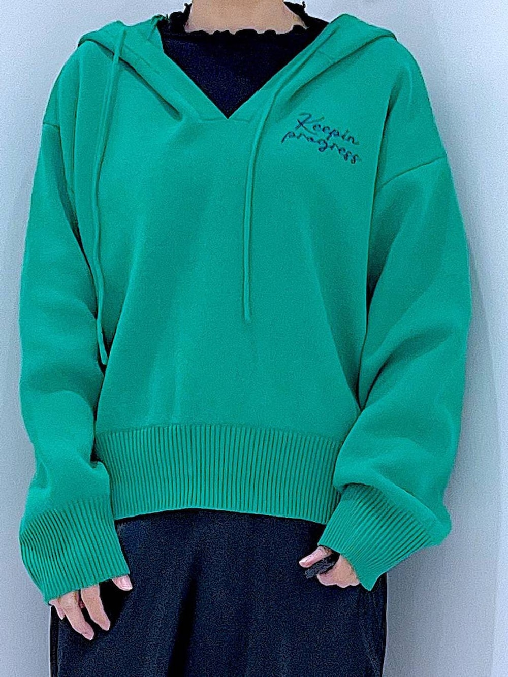 ブラック系のTシャツ/カットソー、ホワイト系のショルダーバッグ、グリーン系のニット/セーターを着用したレディースの春コーディネートの7枚目の写真