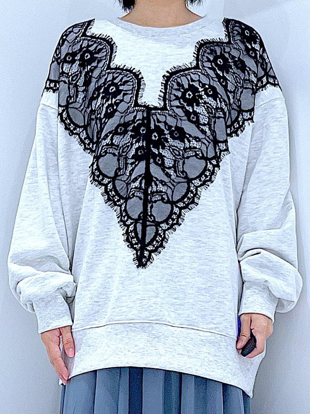 ブラック系のショルダーバッグ、ブラック系のブーツ、ベージュ系のスウェットを着用したレディースの冬コーディネートの7枚目の写真