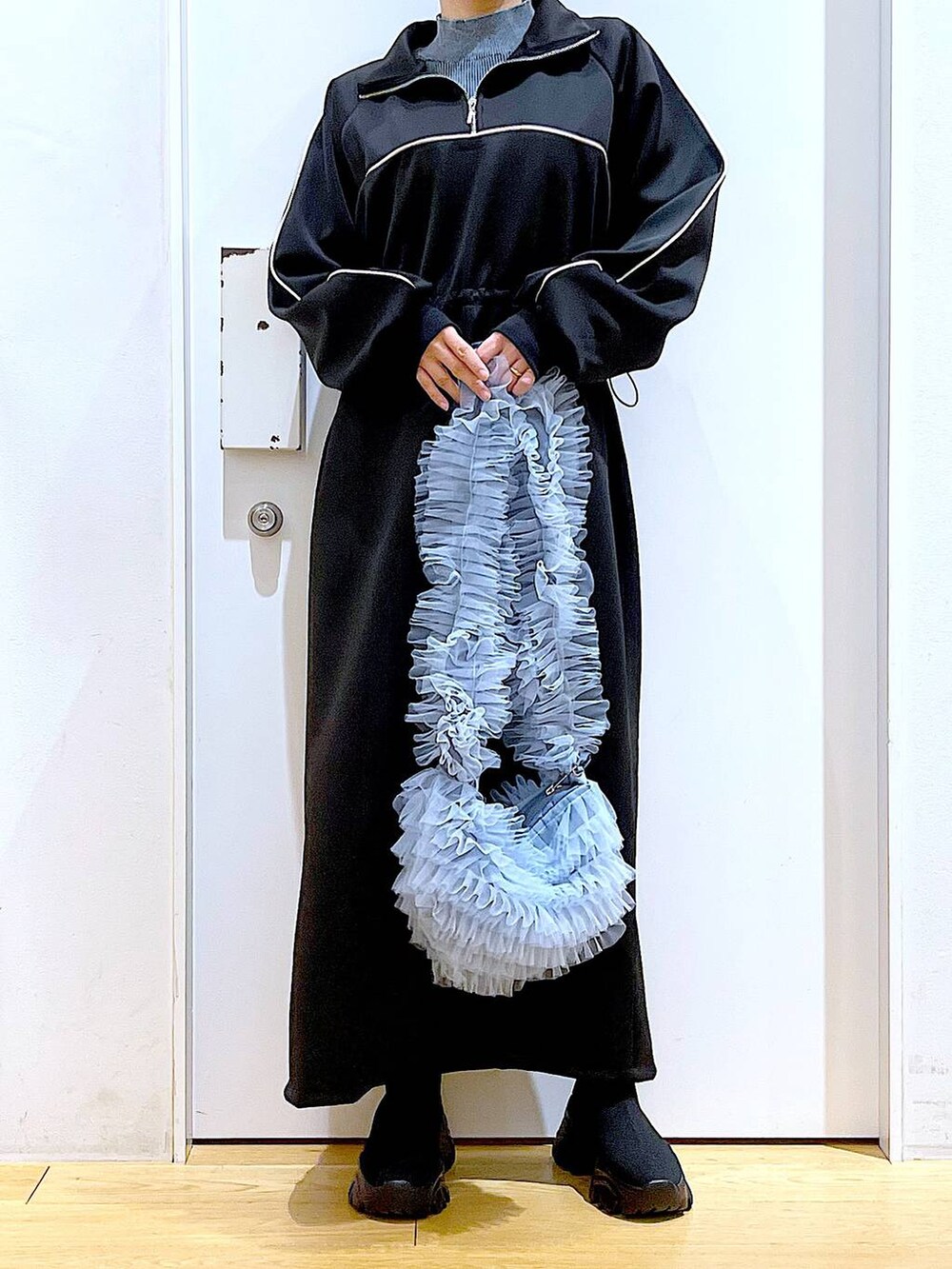 ブラック系のブーツ、ブルー系のショルダーバッグ、ブルー系のニット/セーターを着用したレディースの冬コーディネートの6枚目の写真