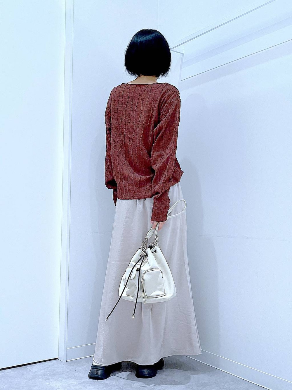 ホワイト系のローファー、ホワイト系のショルダーバッグ、ベージュ系のスカートを着用したレディースの秋コーディネートの5枚目の写真