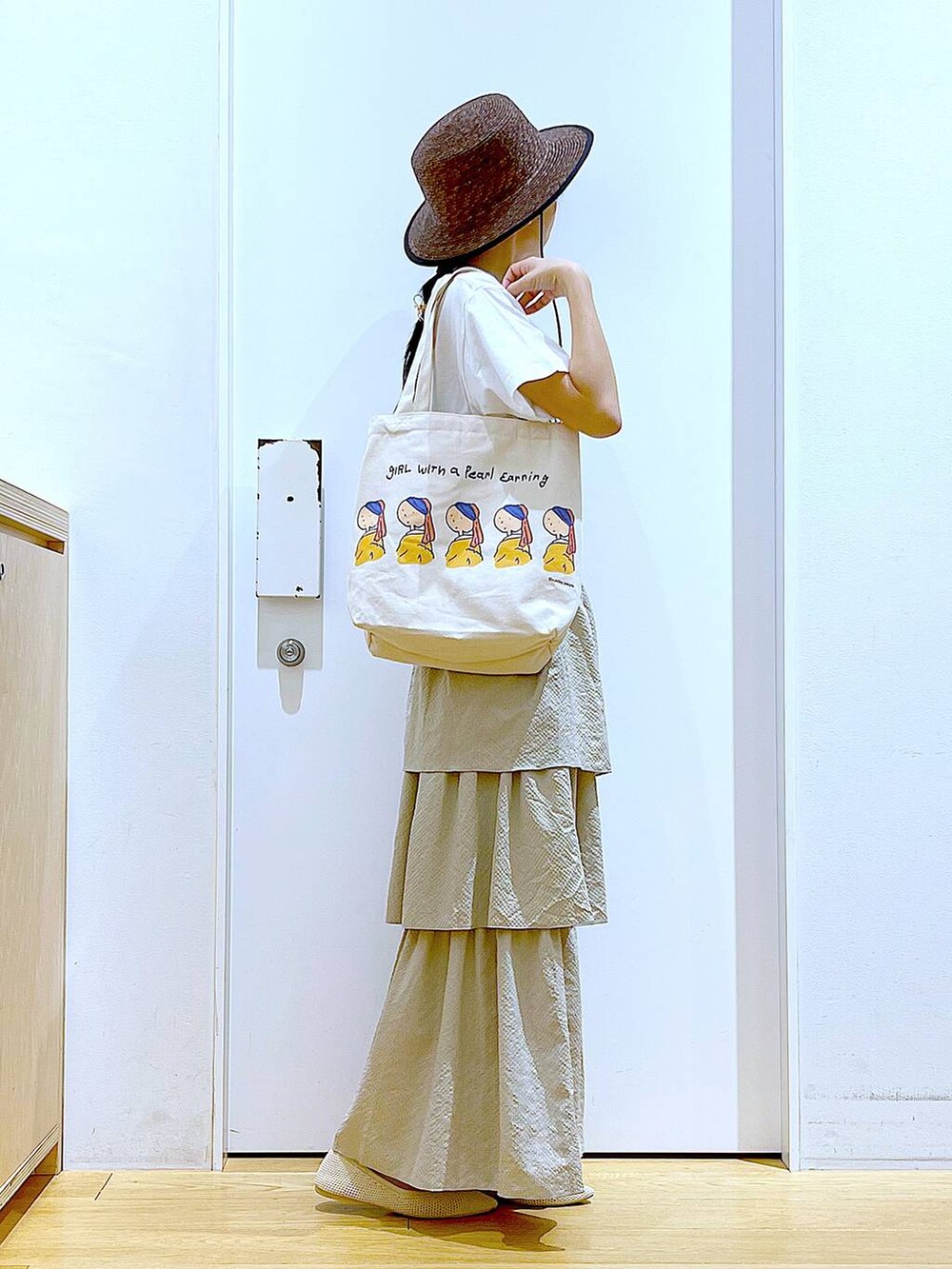 ベージュ系のスカート、ホワイト系のTシャツ/カットソー、その他のトートバッグを着用したレディースの春コーディネートの4枚目の写真