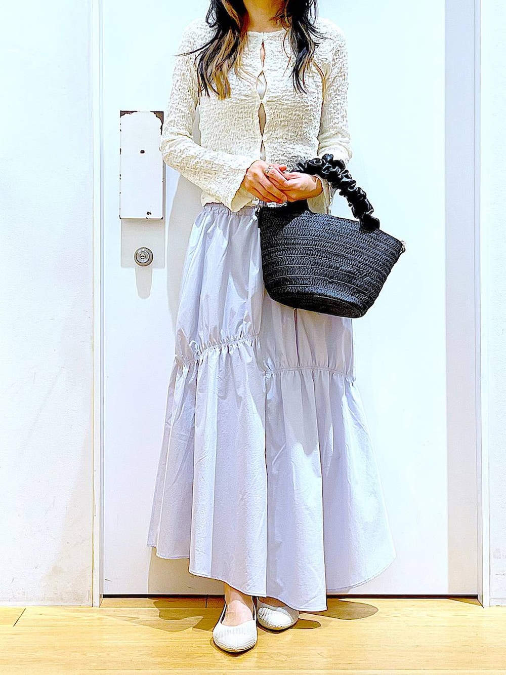 ホワイト系のカーディガン/ボレロ、イエロー系のニット/セーター、ホワイト系のパンプスを着用したレディースの春コーディネートの6枚目の写真