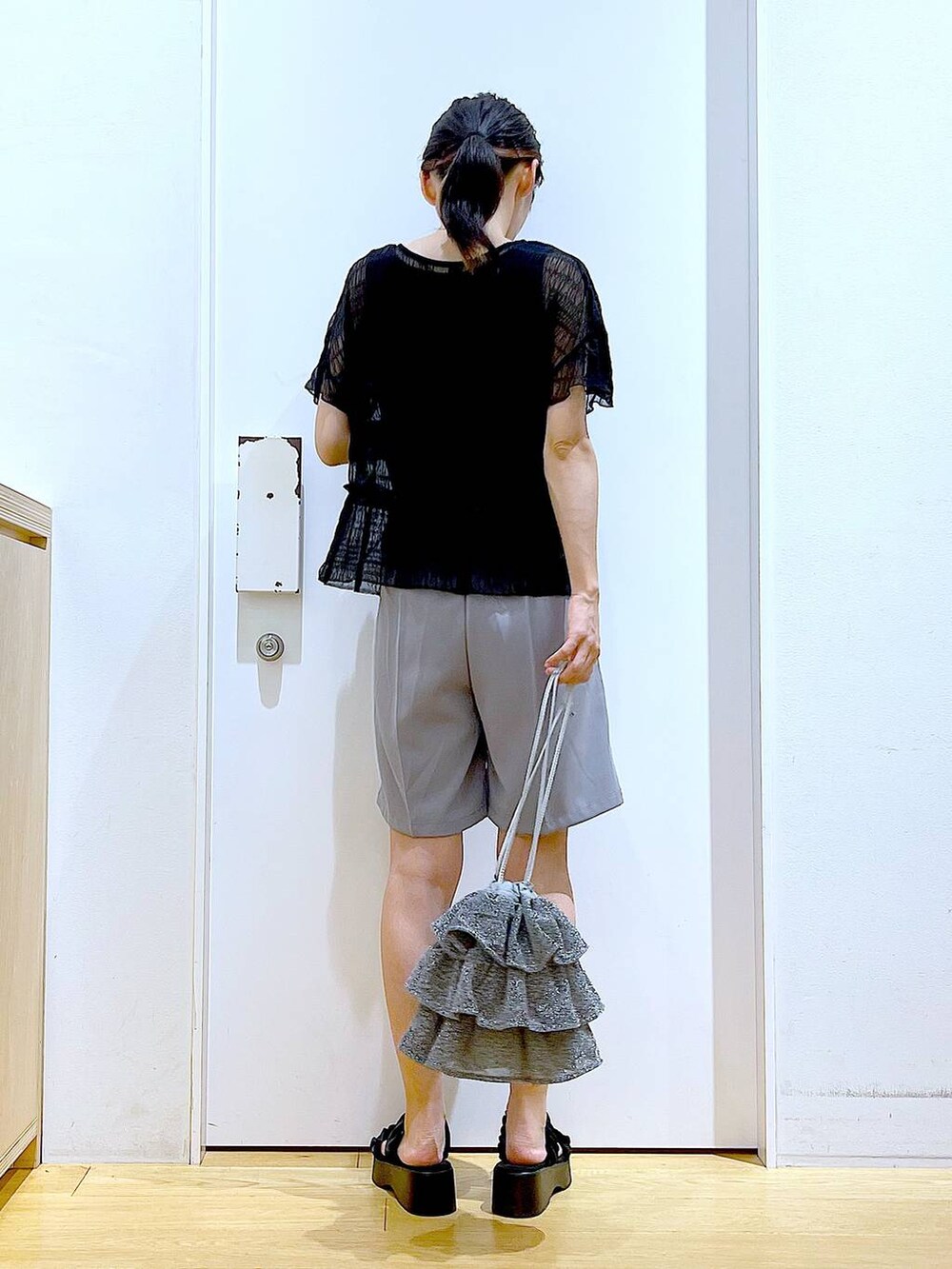 シルバー系のショルダーバッグ、グレー系のその他パンツ、ブラック系のサンダルを着用したレディースの夏コーディネートの5枚目の写真