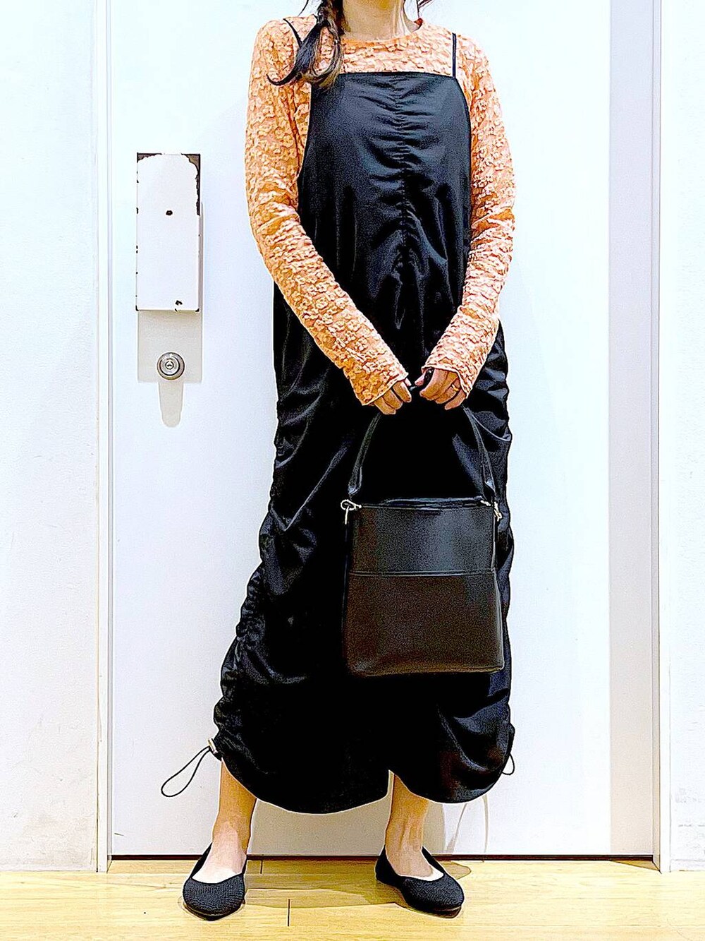 ブラック系のワンピース、ブラック系のショルダーバッグ、ブラック系のパンプスを着用したレディースの春コーディネートの6枚目の写真