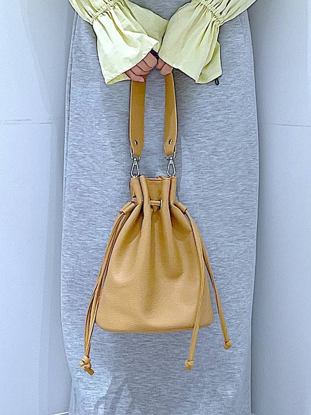 グレー系のスカート、ベージュ系のローファー、ブラウン系のショルダーバッグを着用したレディースの冬コーディネートの9枚目の写真