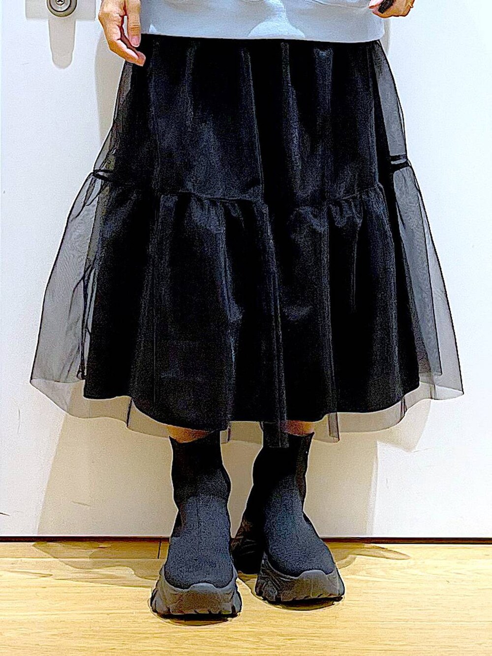 ブルー系のスウェット、ブラック系のブーツ、ホワイト系のショルダーバッグを着用したレディースの春コーディネートの8枚目の写真