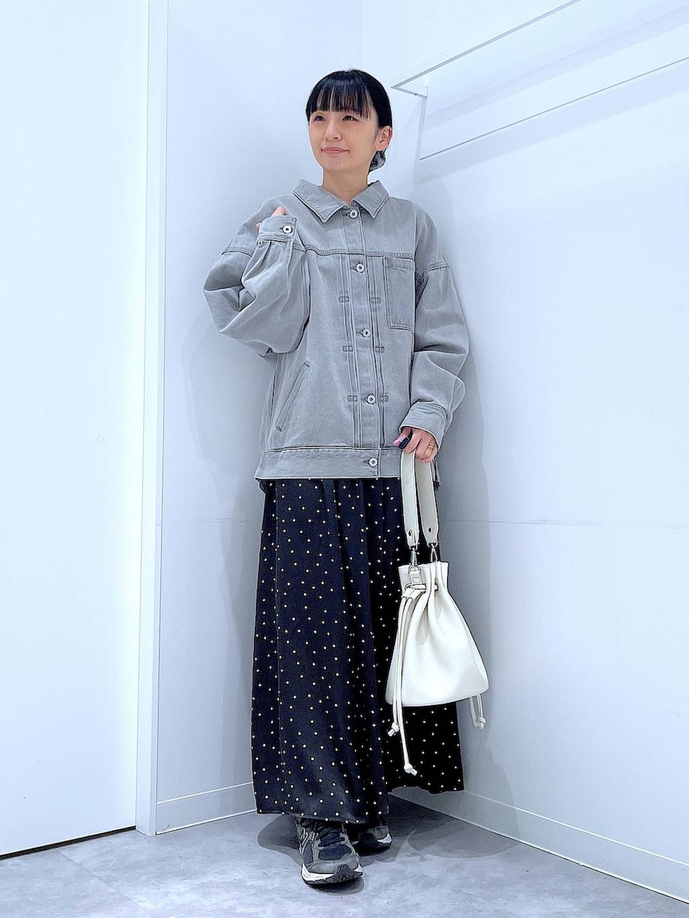 グレー系のデニムジャケット、ホワイト系のショルダーバッグ、グレー系のシュシュを着用したレディースの春コーディネートの2枚目の写真