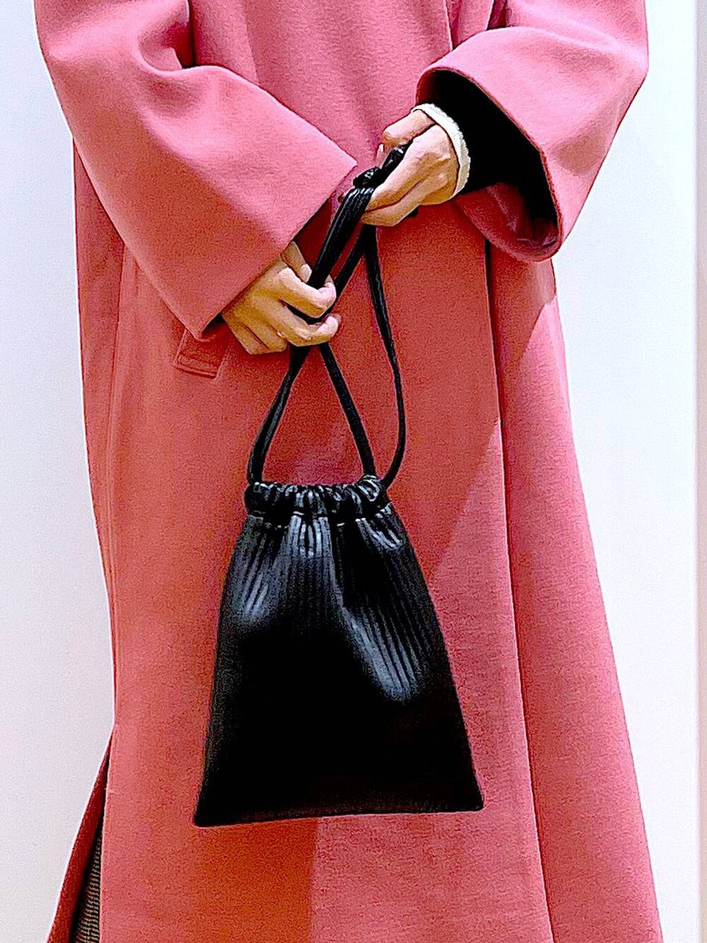 ブラック系のショルダーバッグ、ブラック系のニット/セーター、ベージュ系のスラックスを着用したレディースの冬コーディネートの9枚目の写真