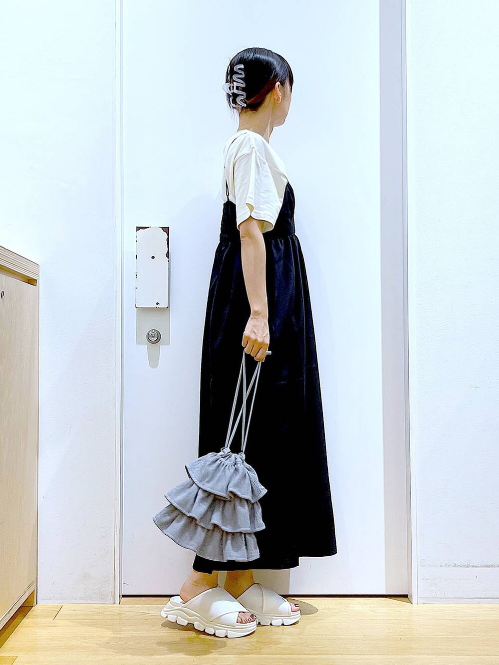 ホワイト系のサンダル、ベージュ系のTシャツ/カットソー、ブラック系のワンピースを着用したレディースの夏コーディネートの4枚目の写真