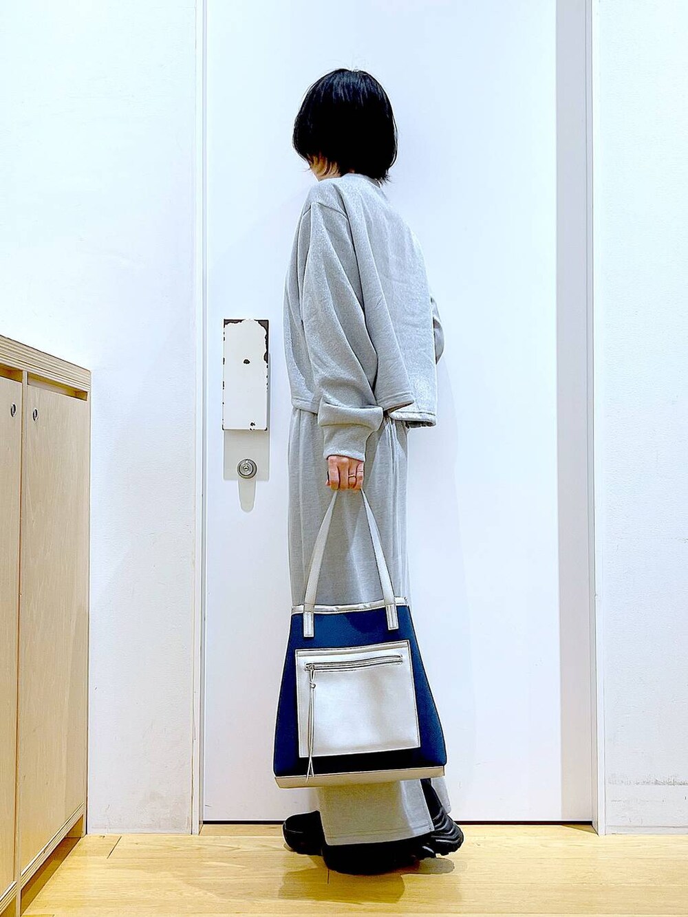 ブラック系のブーツ、ブルー系のトートバッグ、グレー系のスウェットを着用したレディースの冬コーディネートの3枚目の写真