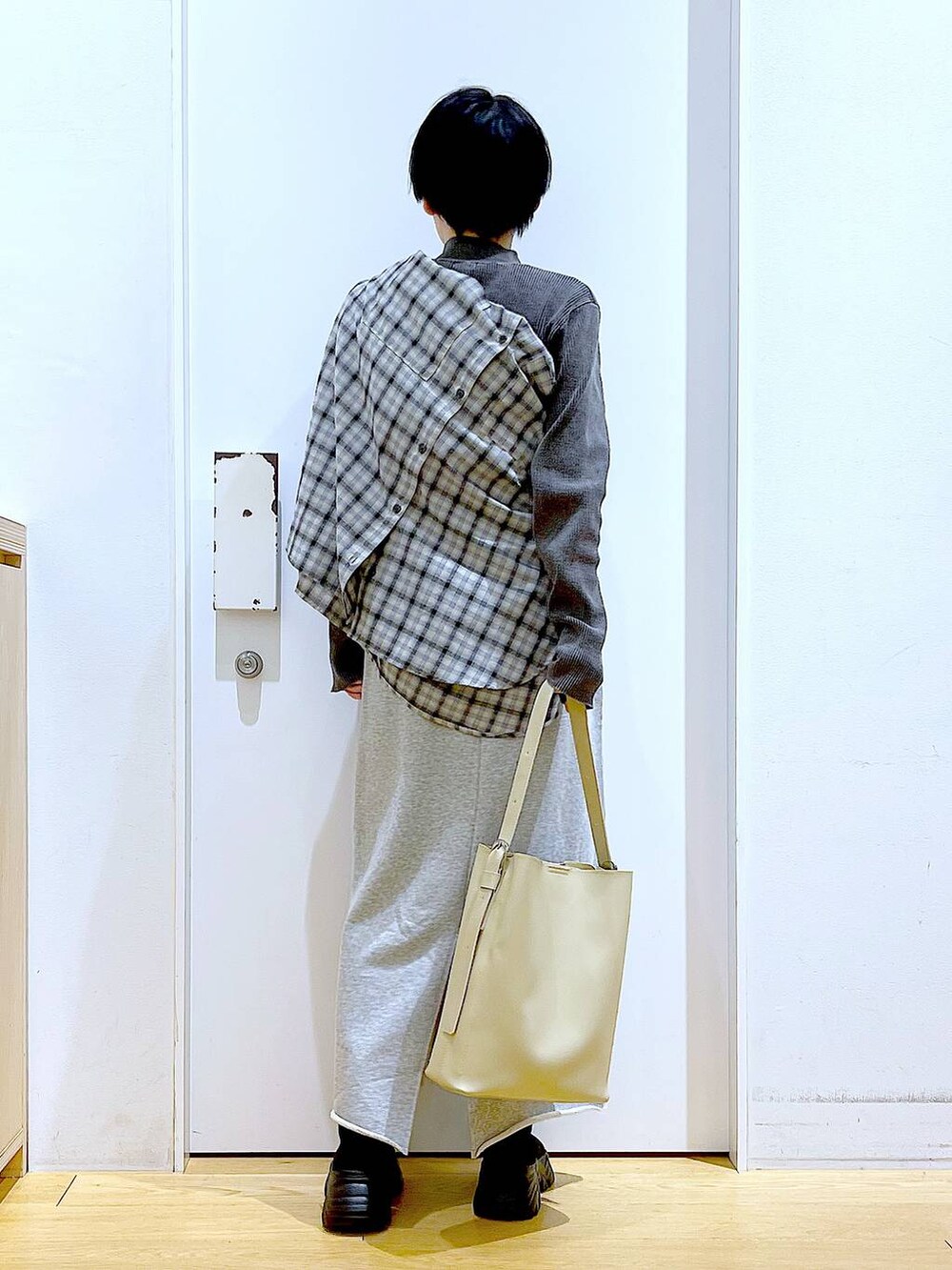 ブラック系のブーツ、ホワイト系のショルダーバッグ、ベージュ系のシャツ/ブラウスを着用したレディースの春コーディネートの5枚目の写真