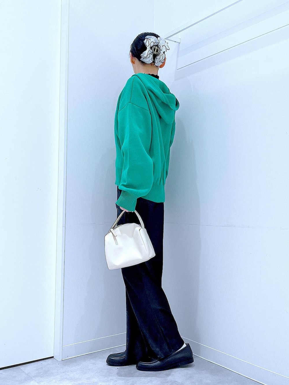 ブラック系のTシャツ/カットソー、ホワイト系のショルダーバッグ、グリーン系のニット/セーターを着用したレディースの春コーディネートの3枚目の写真