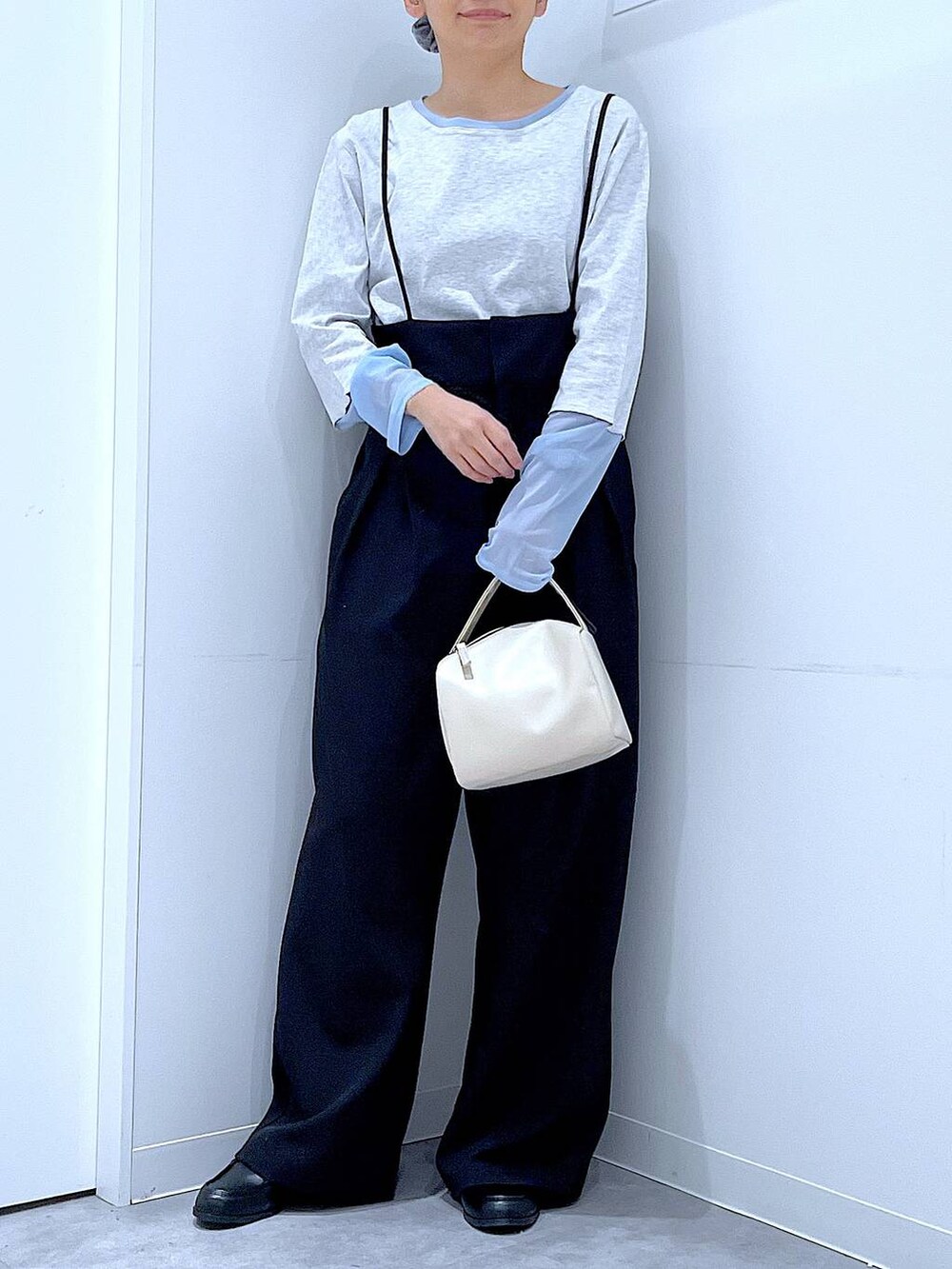 ホワイト系のショルダーバッグ、ブラック系のローファー、ブラック系のサロペット/オーバーオールを着用したレディースの春コーディネートの6枚目の写真