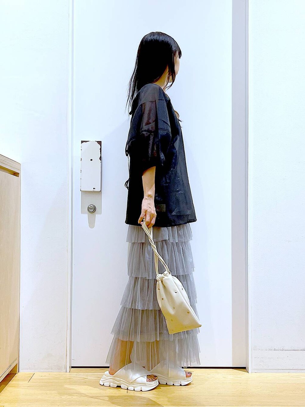 ホワイト系のサンダル、ブラック系のニット/セーター、ホワイト系のショルダーバッグを着用したレディースの夏コーディネートの4枚目の写真