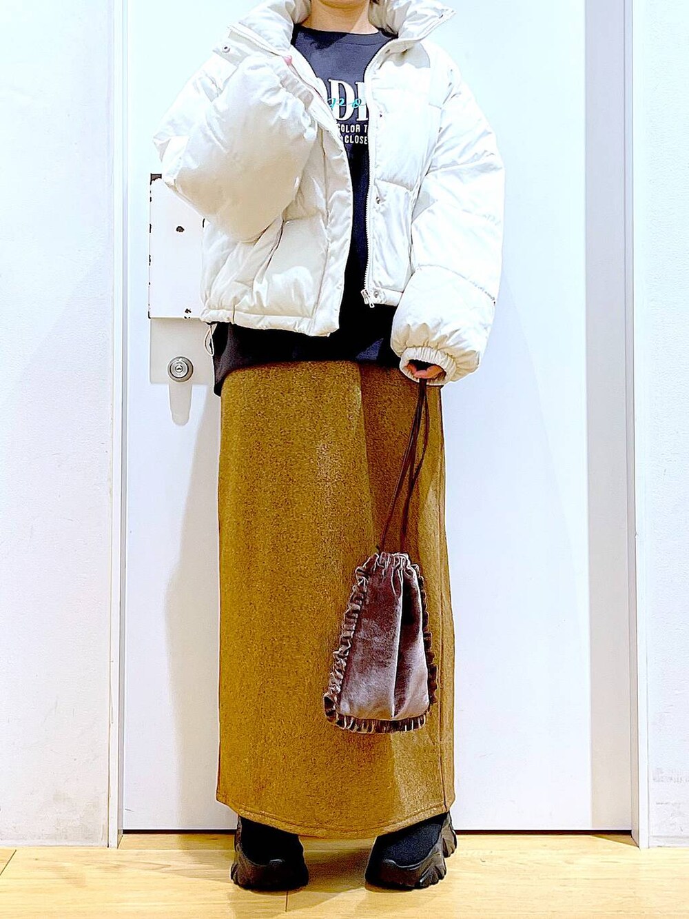 ベージュ系のブルゾン、ブラウン系のショルダーバッグ、ブラック系のブーツを着用したレディースの冬コーディネートの6枚目の写真