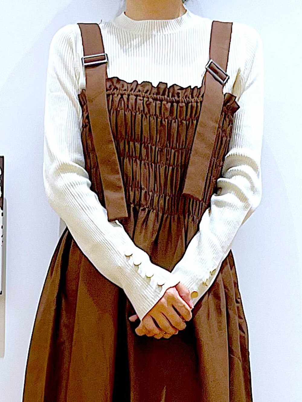 ホワイト系のニット/セーター、ホワイト系のハンドバッグ、ベージュ系のスリッポンを着用したレディースの冬コーディネートの7枚目の写真