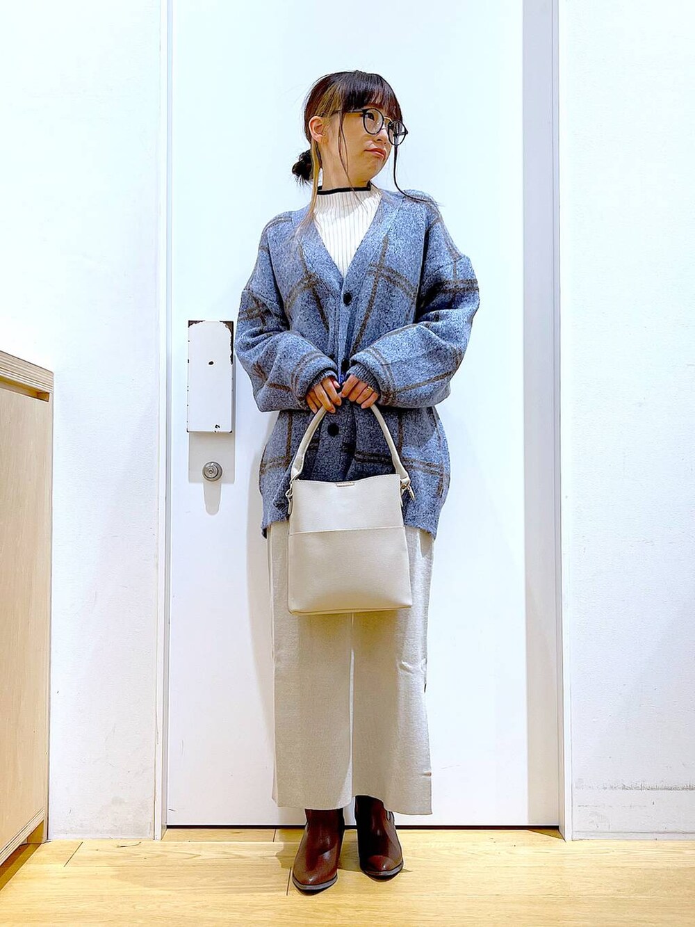ブルー系のカーディガン/ボレロ、グレー系のショルダーバッグ、グレー系のスカートを着用したレディースの冬コーディネートの2枚目の写真