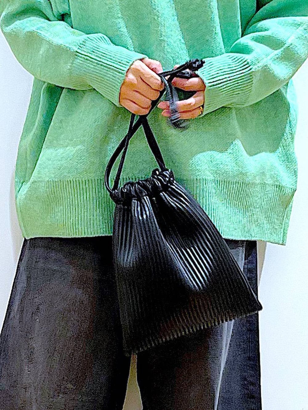 ブラック系のショルダーバッグ、ブラック系のブーツ、ブラック系のデニムパンツを着用したレディースの冬コーディネートの9枚目の写真