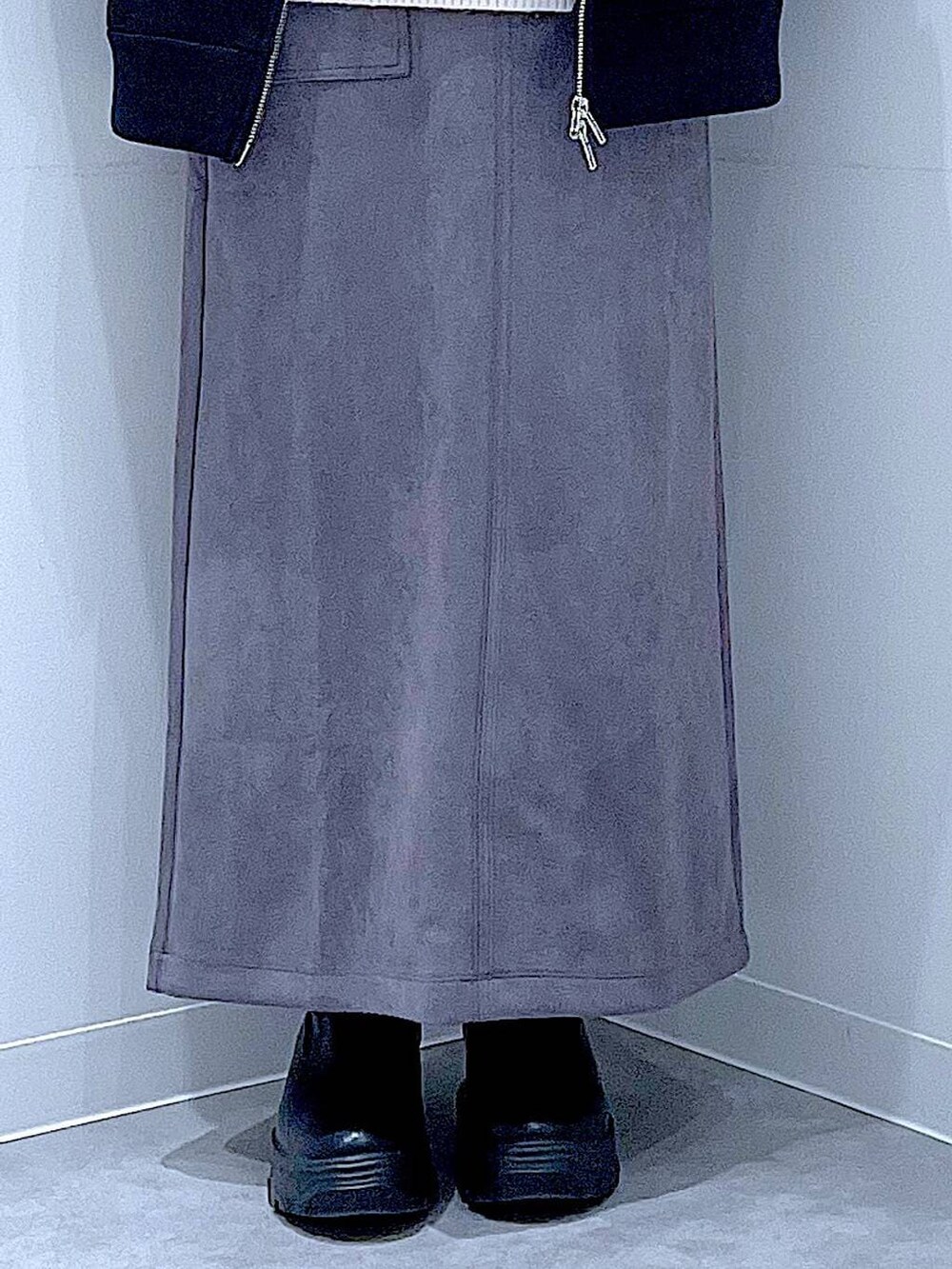 ホワイト系のハンドバッグ、ブラック系のブーツ、グレー系のスカートを着用したレディースの冬コーディネートの8枚目の写真