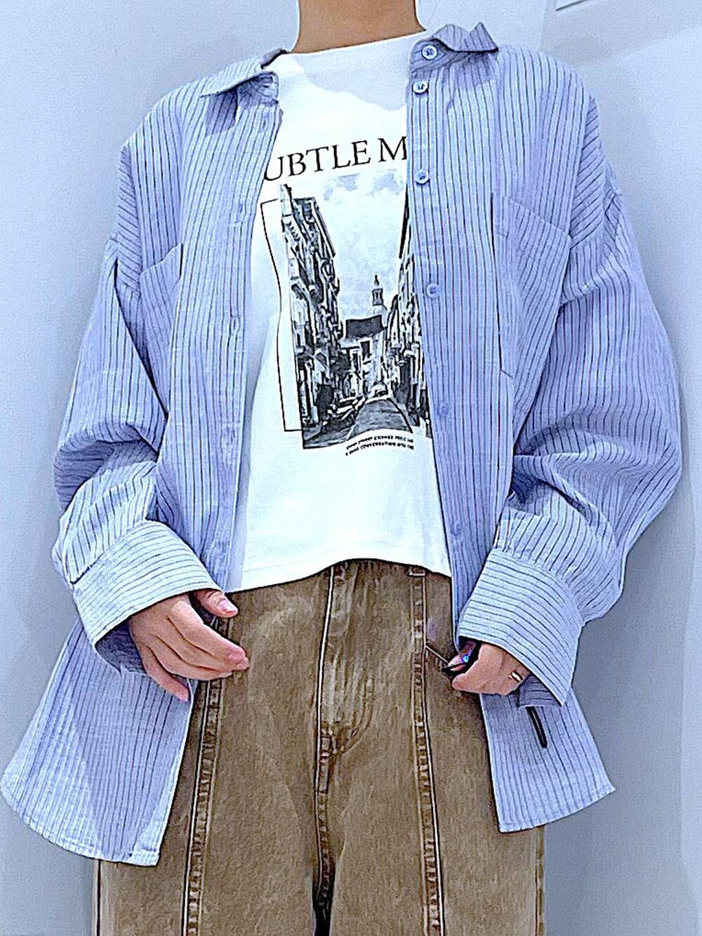 ブラック系のブーツ、グレー系のトートバッグ、ベージュ系のデニムパンツを着用したレディースの春コーディネートの7枚目の写真