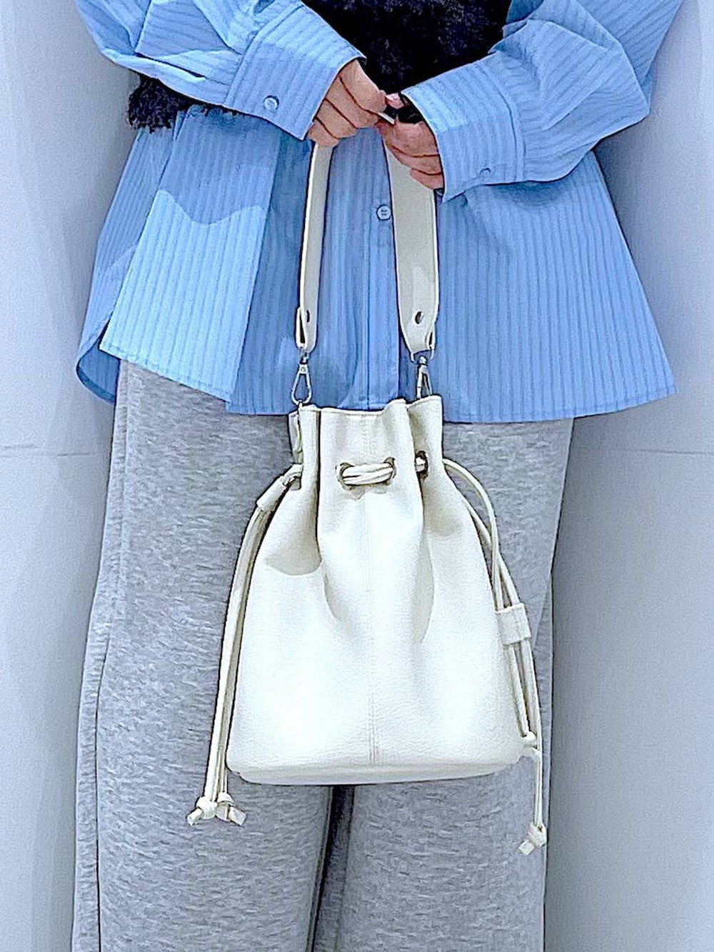 ブルー系のシャツ/ブラウス、ホワイト系のショルダーバッグ、グレー系のベストを着用したレディースの春コーディネートの9枚目の写真