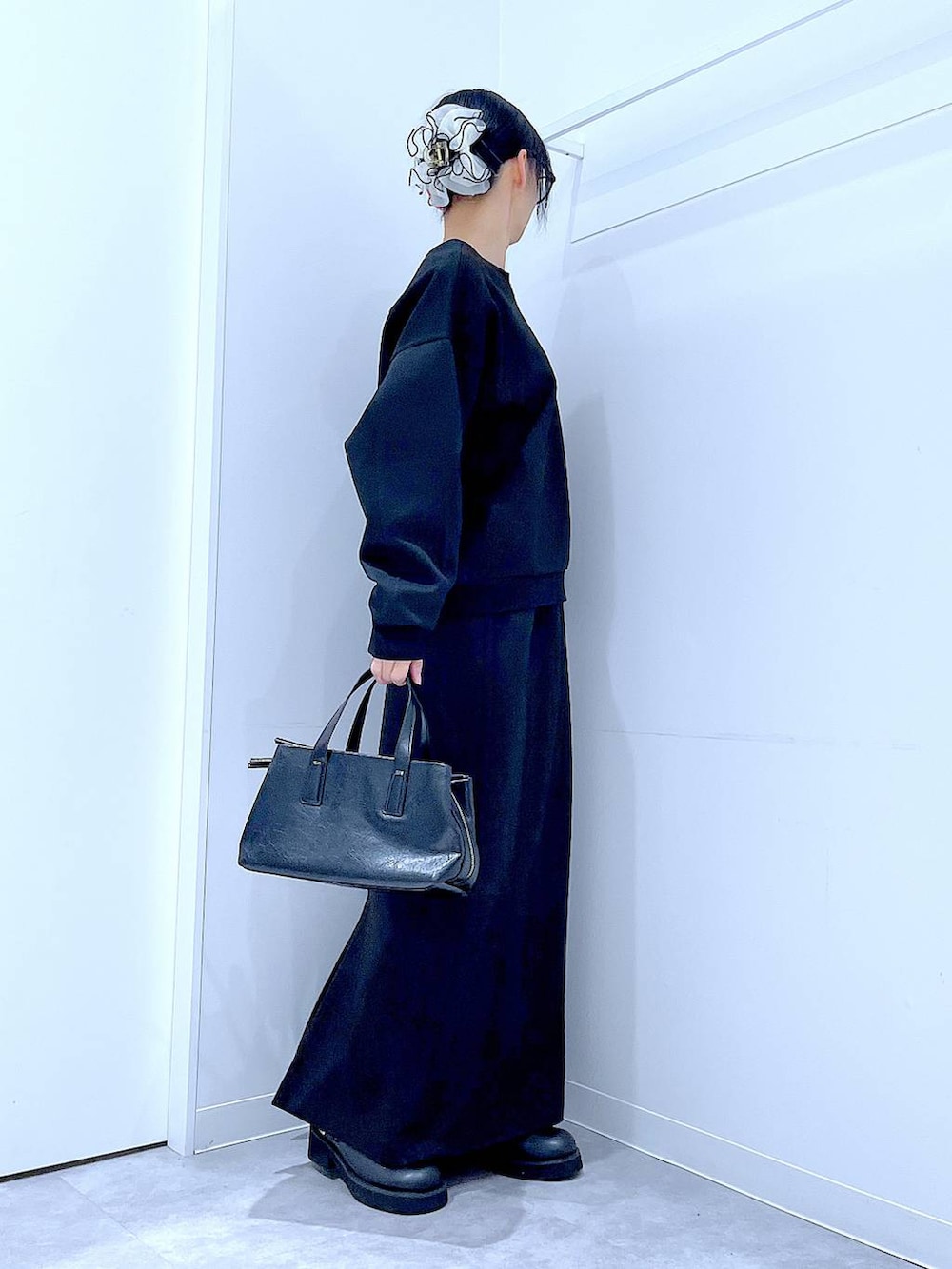 ブラック系のボストンバッグ、ブラック系のスウェット、ブラック系のスカートを着用したレディースの春コーディネートの4枚目の写真