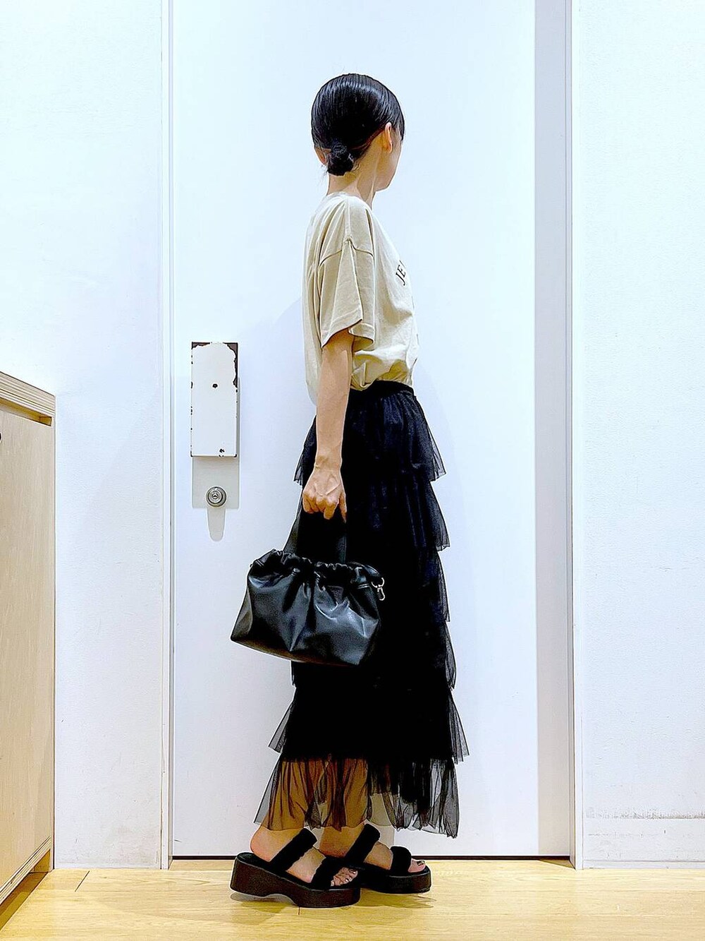 ブラック系のサンダル、ブラック系のショルダーバッグ、ブラック系のスカートを着用したレディースの夏コーディネートの4枚目の写真