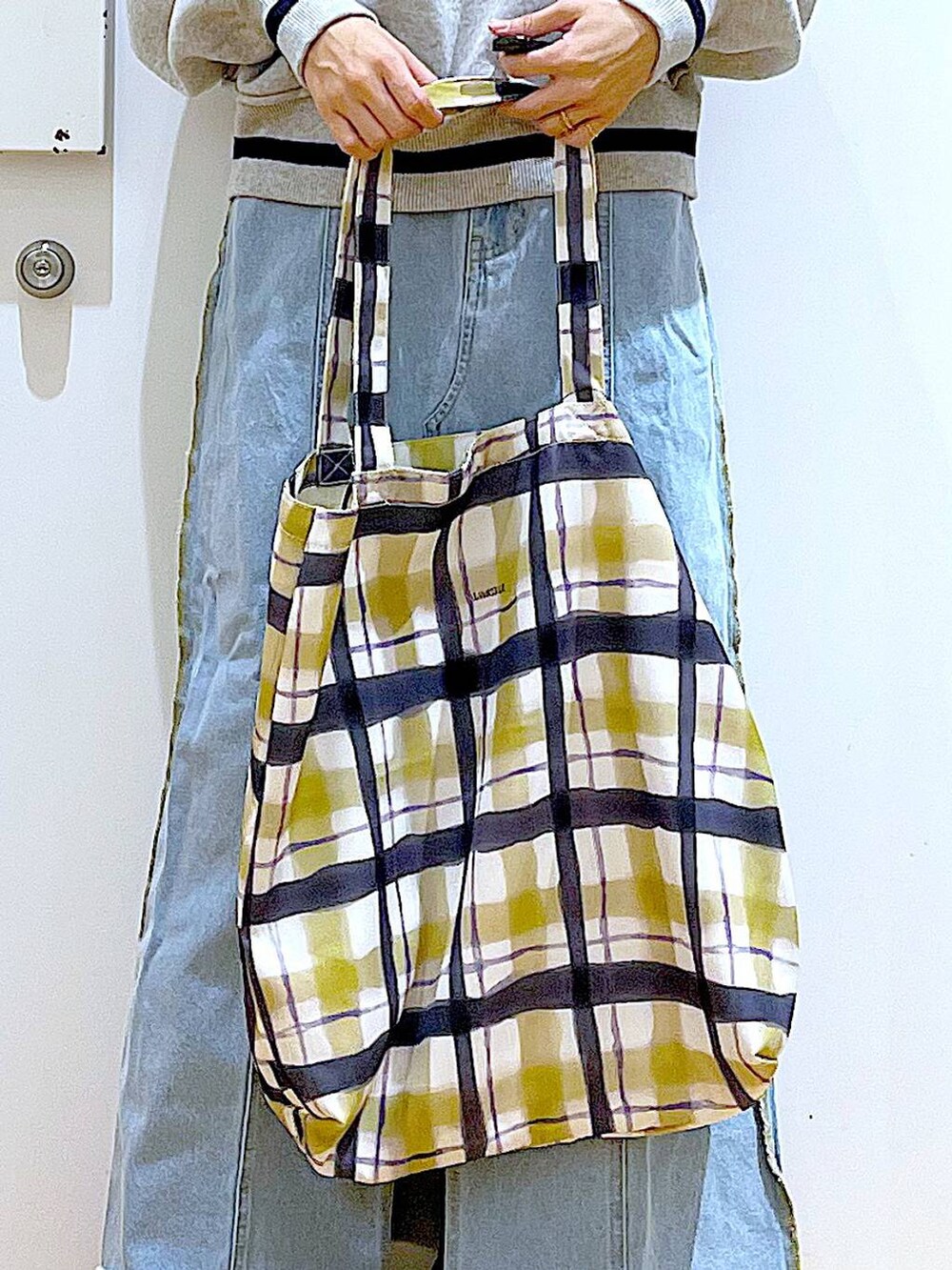 ブルー系のデニムスカート、その他のトートバッグ、ブラック系のブーツを着用したレディースの冬コーディネートの9枚目の写真