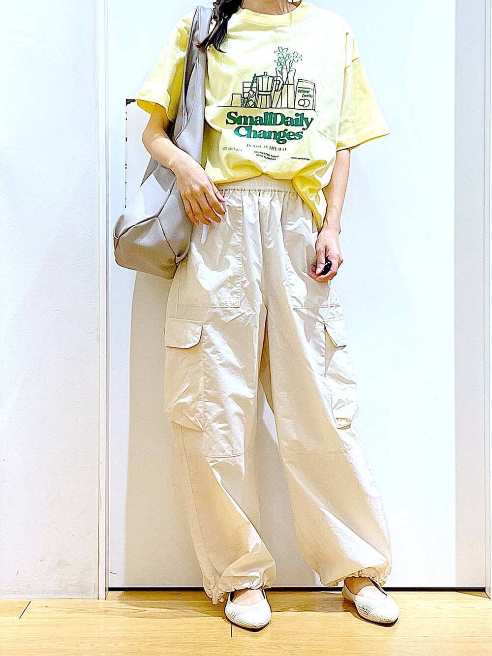 グレー系のトートバッグ、ホワイト系のカーゴパンツ、ホワイト系のパンプスを着用したレディースの春コーディネートの6枚目の写真