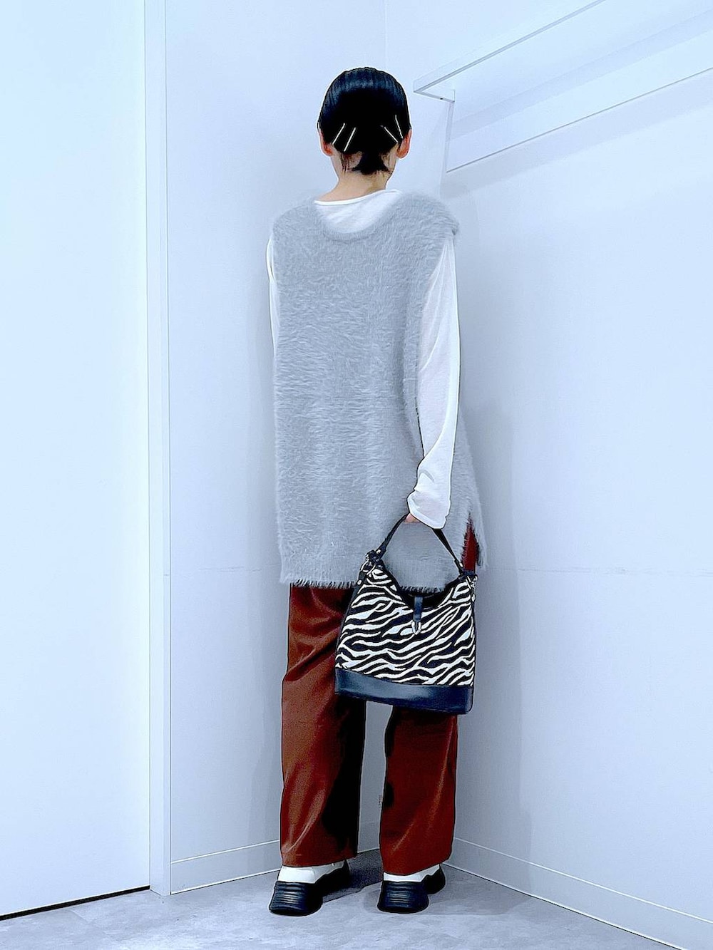 ホワイト系のTシャツ/カットソー、ホワイト系のローファー、グレー系のベストを着用したレディースの秋コーディネートの5枚目の写真