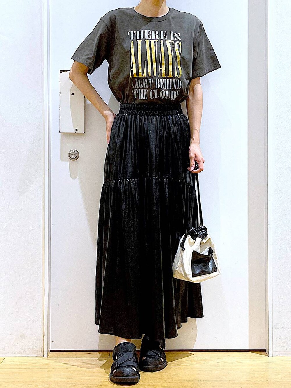 ホワイト系のショルダーバッグ、ブラック系のスリッポン、グレー系のTシャツ/カットソーを着用したレディースの夏コーディネートの6枚目の写真