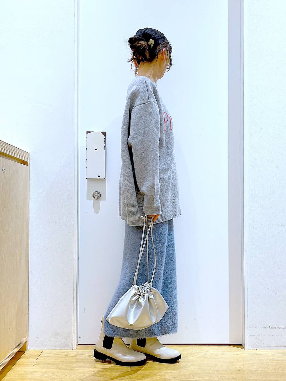 ベージュ系のブーツ、シルバー系のショルダーバッグ、ブルー系のスカートを着用したレディースの冬コーディネートの4枚目の写真