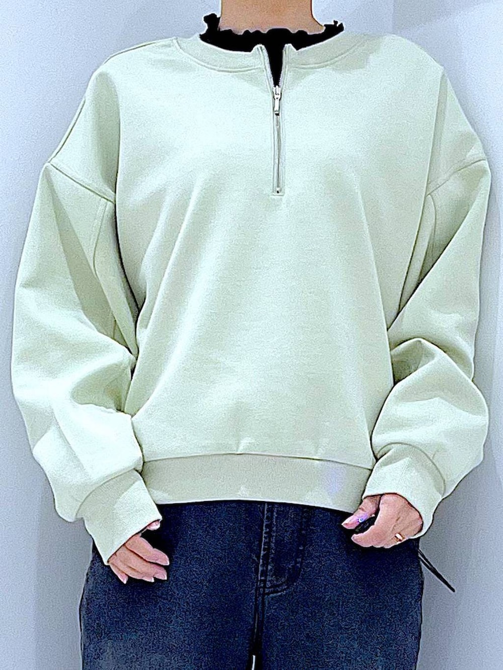 ホワイト系のショルダーバッグ、グリーン系のスウェット、ブラック系のデニムパンツを着用したレディースの春コーディネートの7枚目の写真