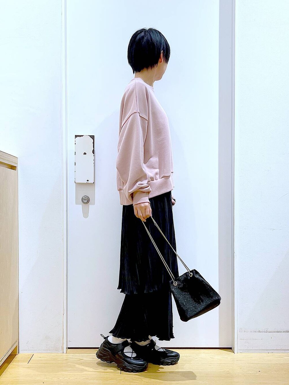 ブラック系のショルダーバッグ、ブラック系のスニーカー、ピンク系のスウェットを着用したレディースの春コーディネートの4枚目の写真