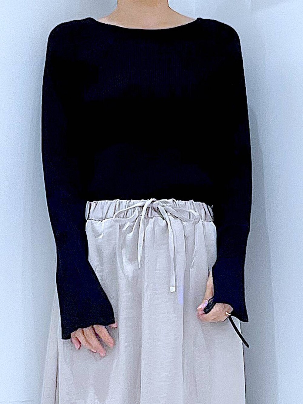 ブラック系のニット/セーター、ベージュ系のスカート、レッド系のショルダーバッグを着用したレディースの秋コーディネートの7枚目の写真