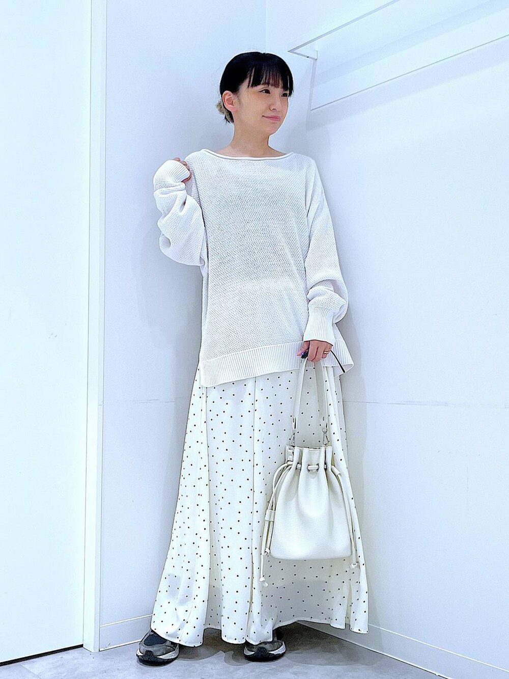 ホワイト系のショルダーバッグ、ホワイト系のスカート、グレー系のバレッタ/ヘアクリップを着用したレディースの春コーディネートの2枚目の写真