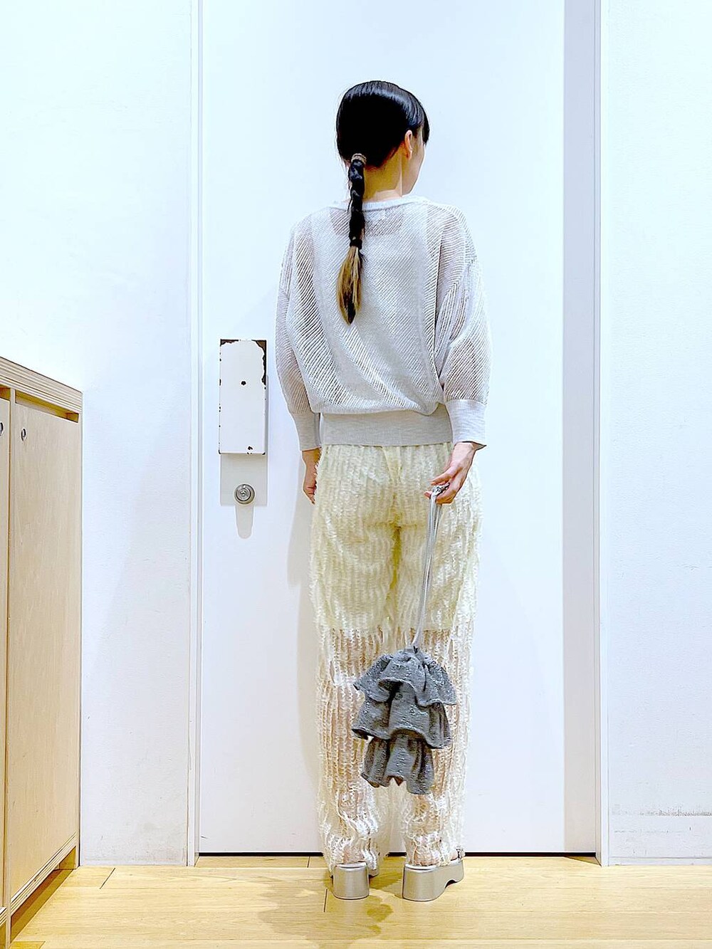 シルバー系のショルダーバッグ、ホワイト系のニット/セーター、ホワイト系のその他パンツを着用したレディースの夏コーディネートの5枚目の写真