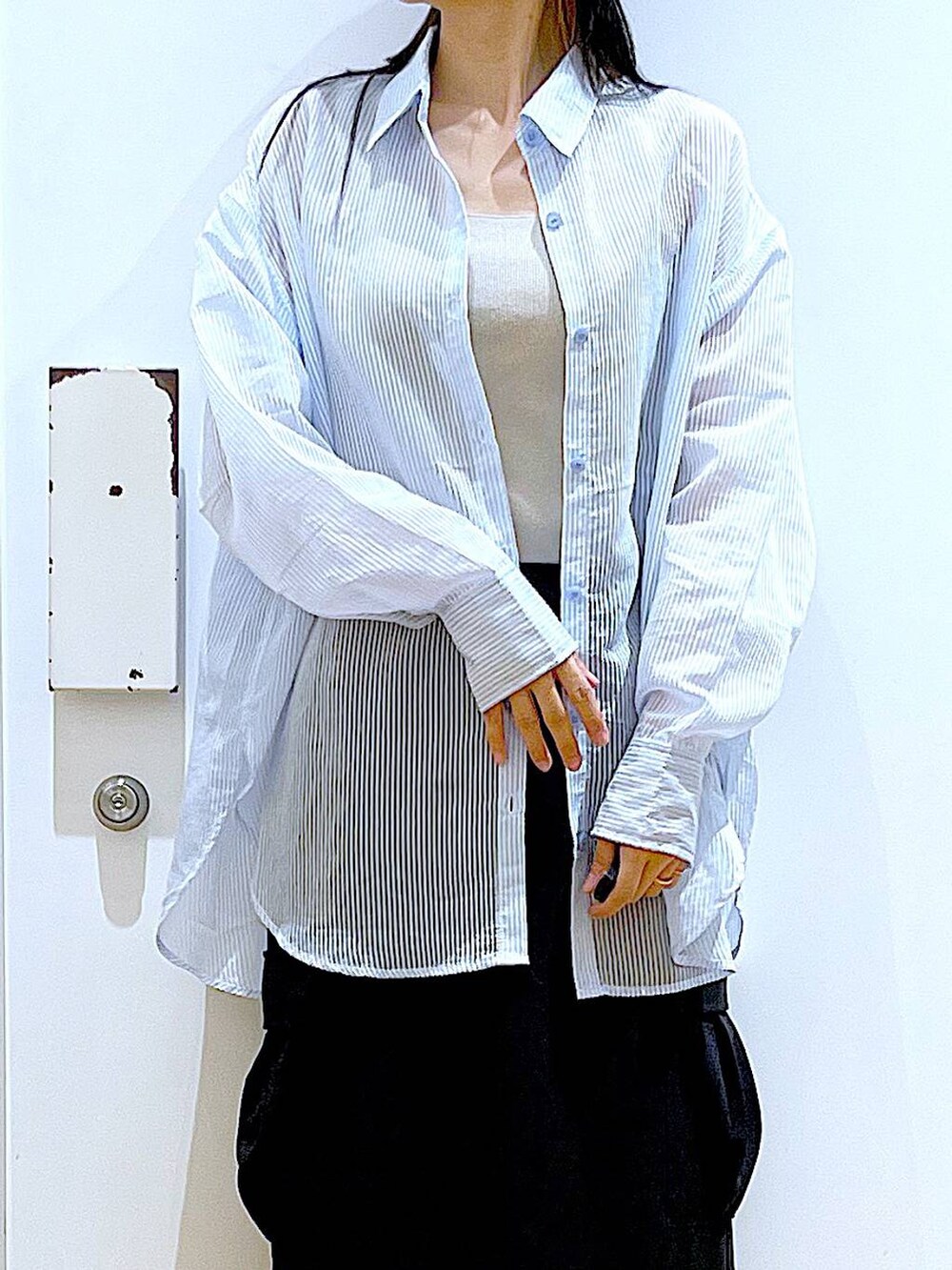 シルバー系のショルダーバッグ、ブラック系のパンプス、ブラック系のスカートを着用したレディースの春コーディネートの7枚目の写真