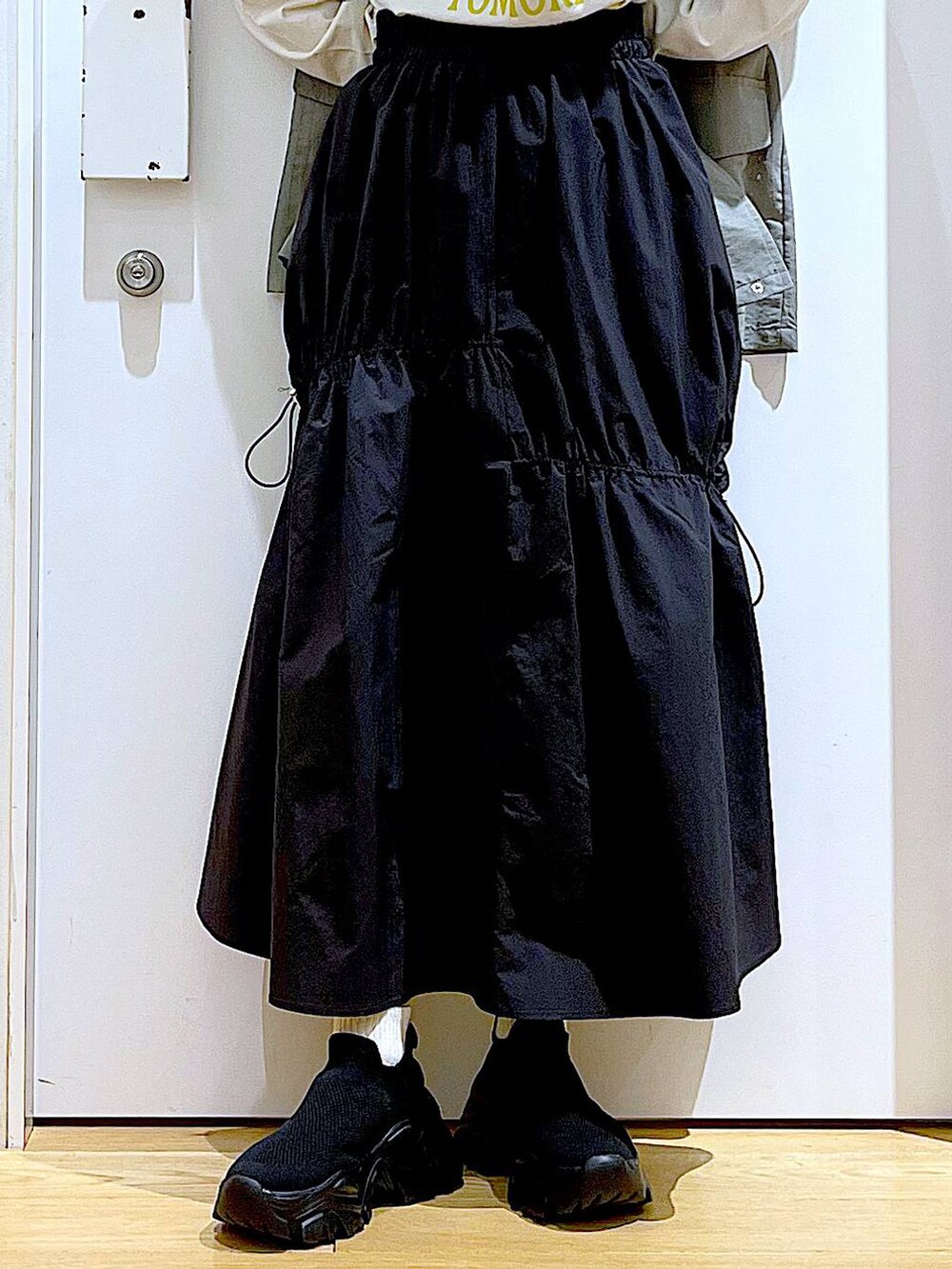 ブラック系のショルダーバッグ、ブラック系のスニーカー、ブラック系のスカートを着用したレディースの春コーディネートの8枚目の写真