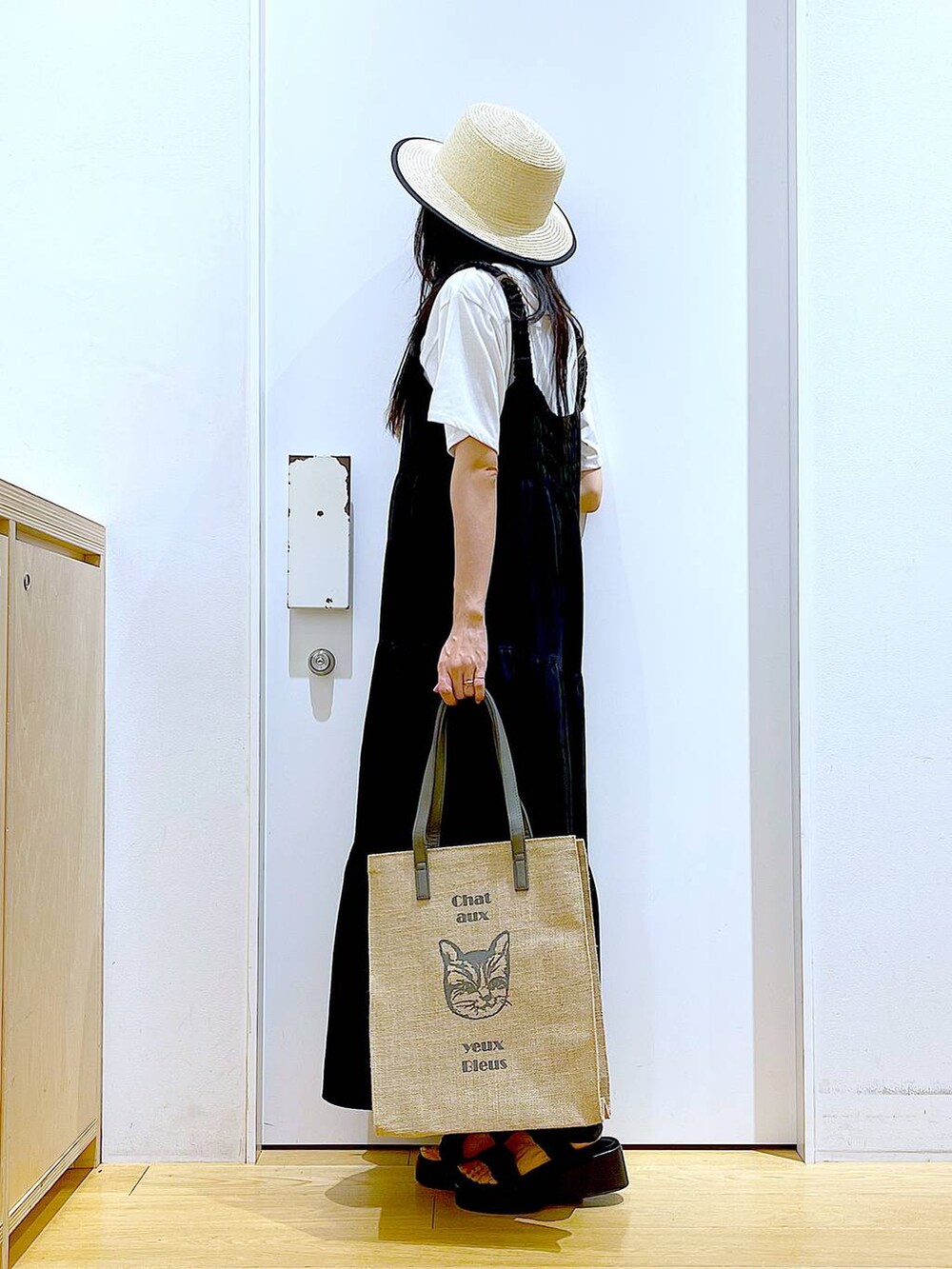 ブラック系のサンダル、グレー系のトートバッグ、ホワイト系のTシャツ/カットソーを着用したレディースの夏コーディネートの3枚目の写真